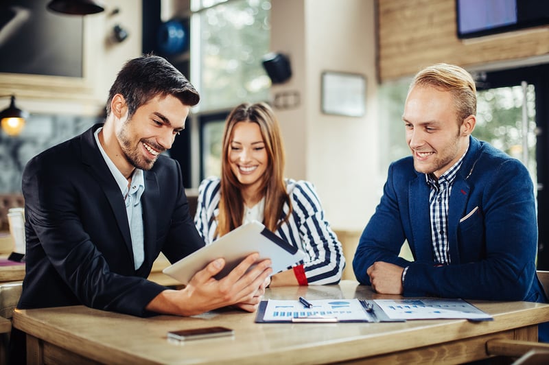 Learning People | 3 project managers at desk with tablet and smiling